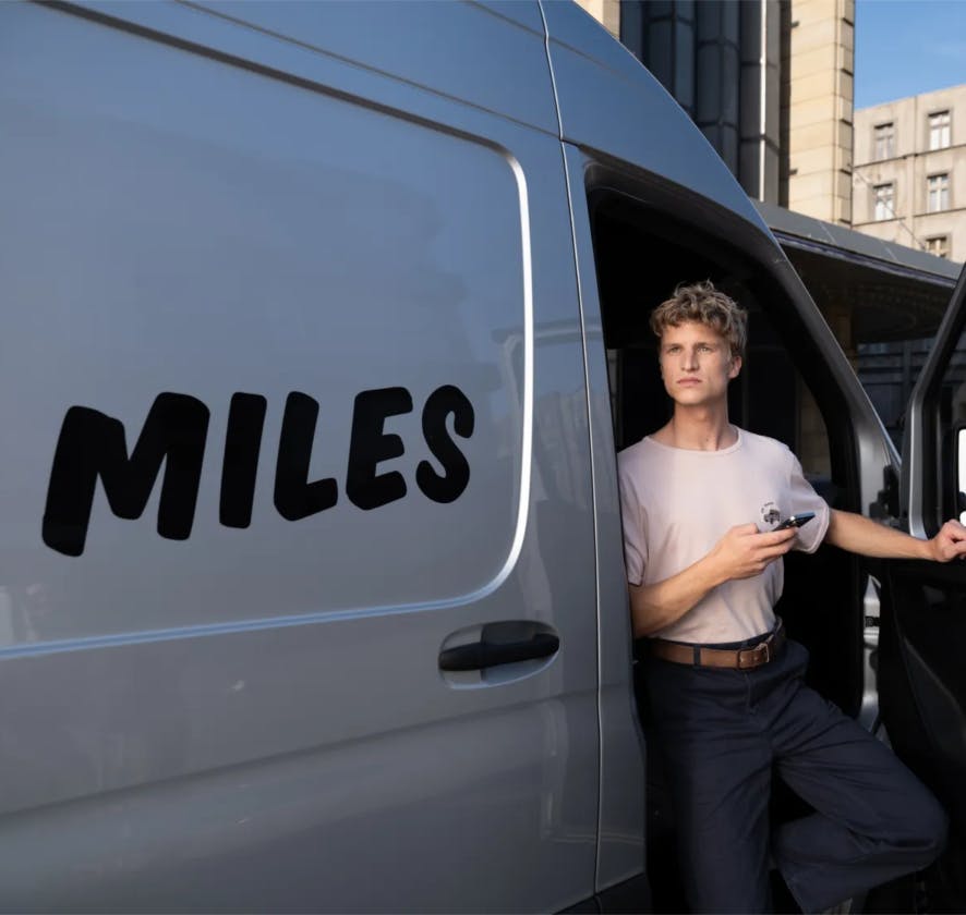 A MILES van with a driver alongside it